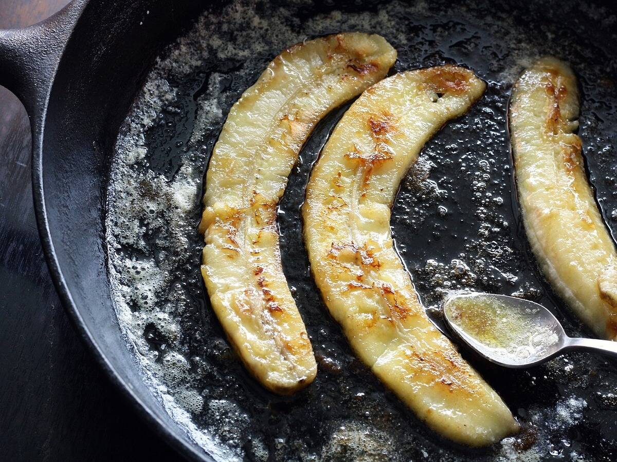 Bananas caramelizing in a well-seasoned cast iron pan.